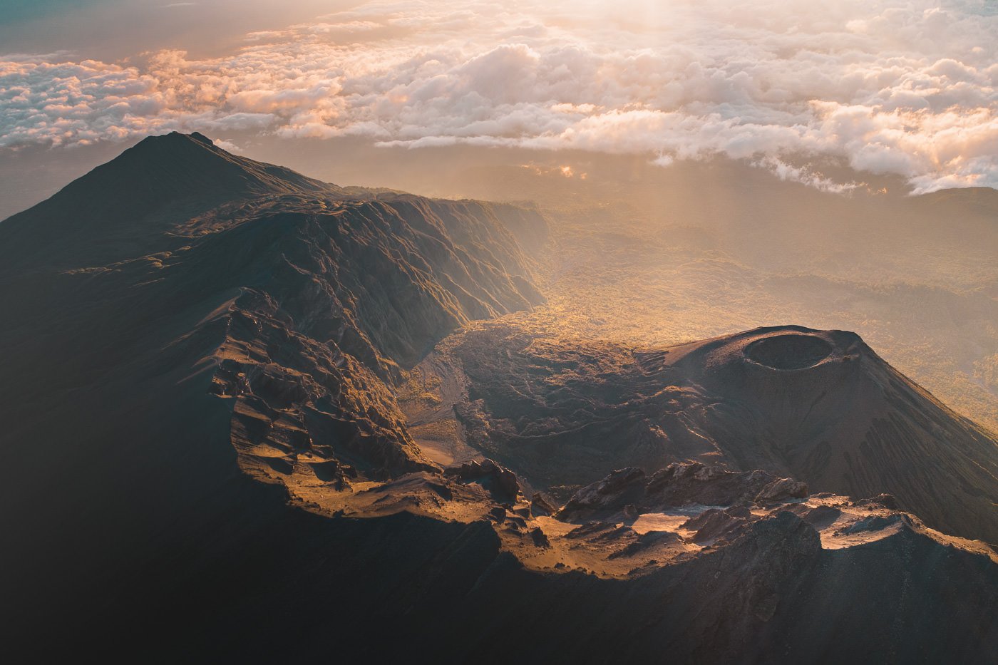 an aerial view of a mountain range with clouds.