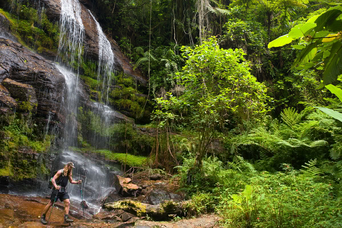 a man standing in front of a waterfall
