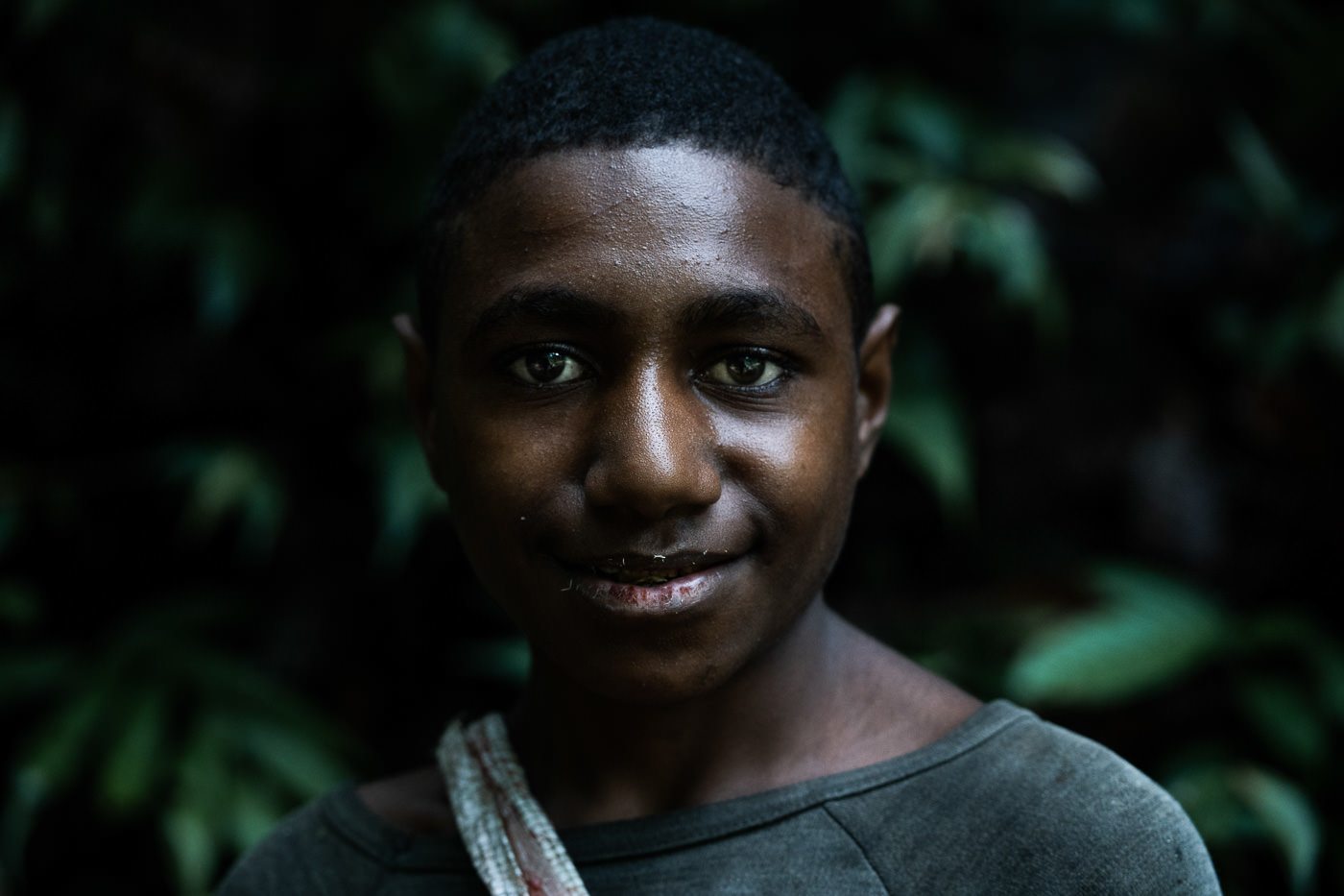 a young man with a necklace around his neck.