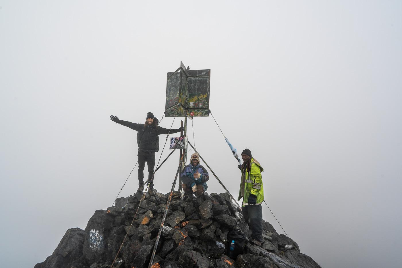 a group of people standing on top of a mountain.