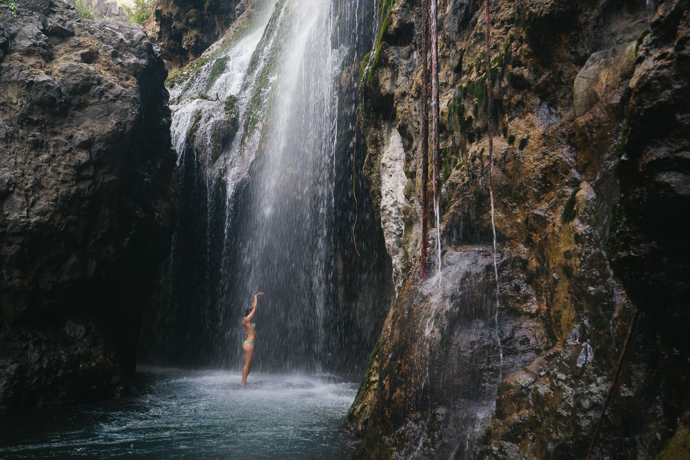 a woman standing in front of a waterfall