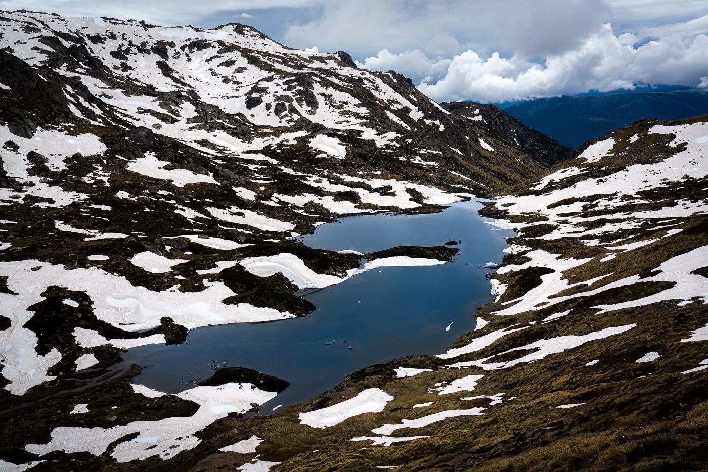 a lake in the middle of a snow covered mountain