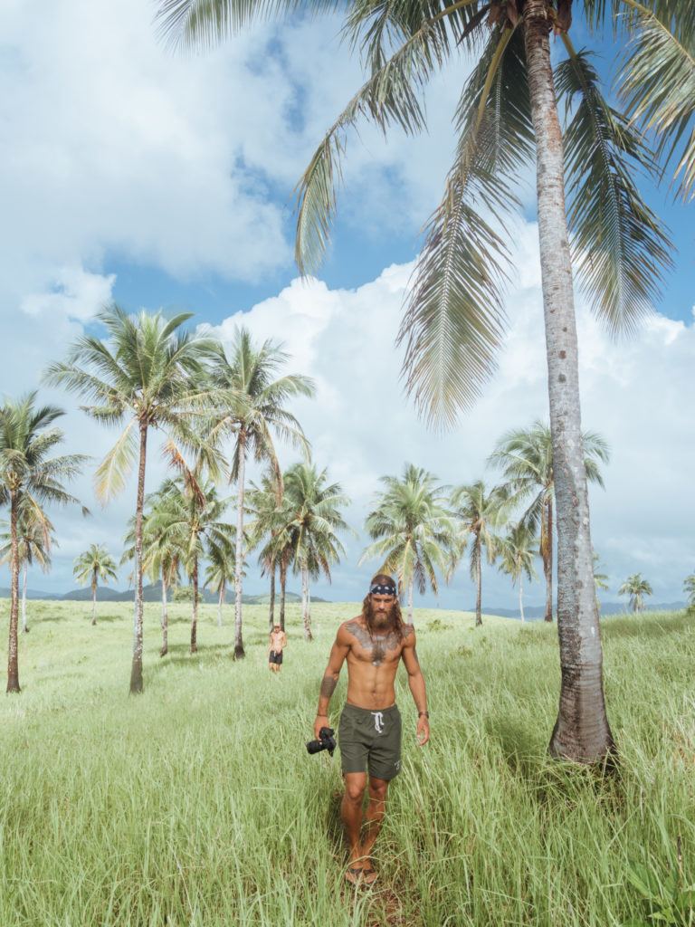 a man walking through a lush green field.